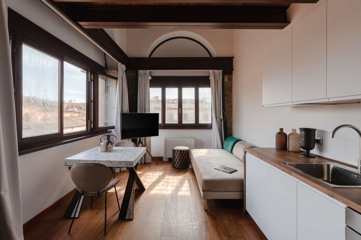 Studio con cucina a vista e pavimento in legno