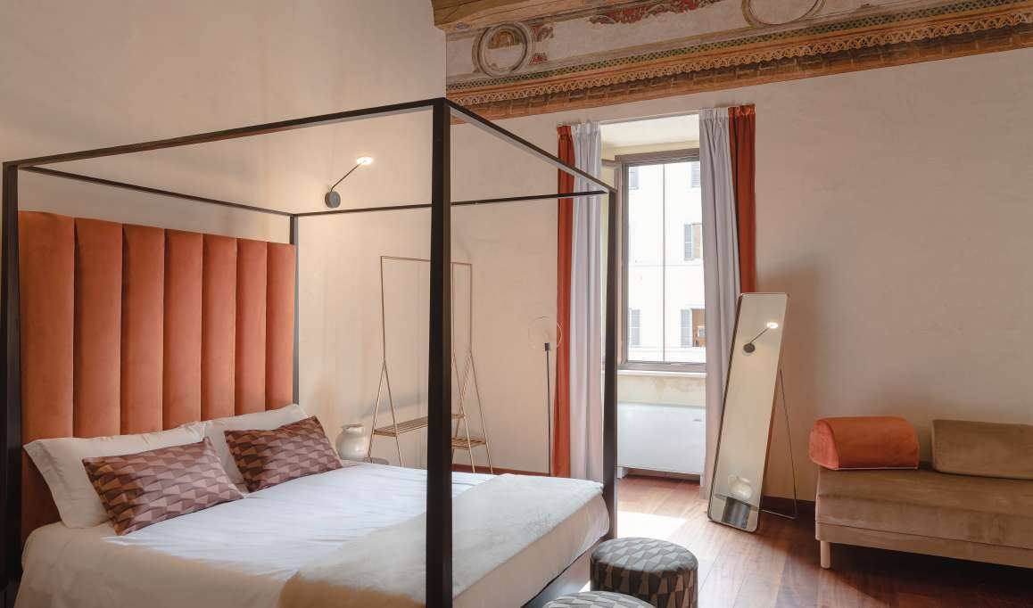 Camera con letto a baldacchino e cornice affrescata
