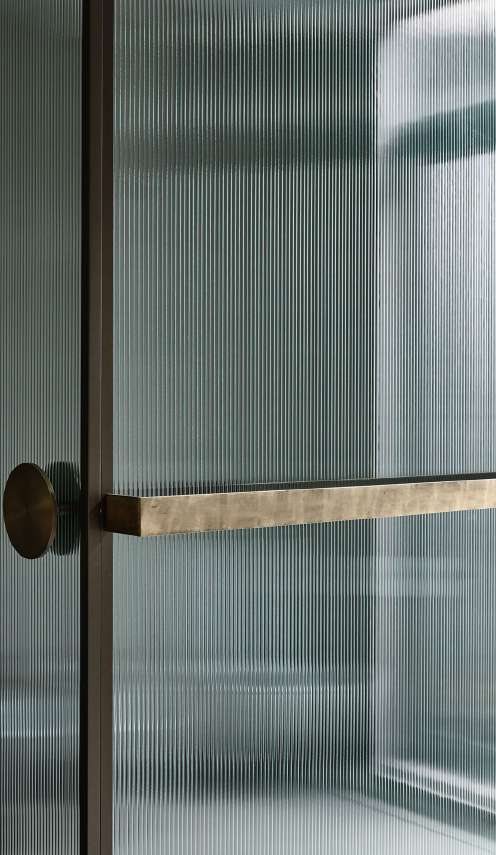 Porta in vetro cannettato con maniglia in ottone